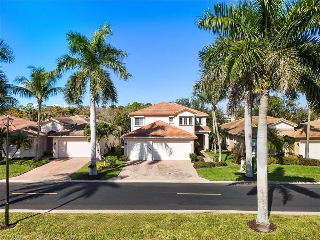Mediterranean / spanish-style home with decorative driveway, a residential view, a front lawn, and a tile roof