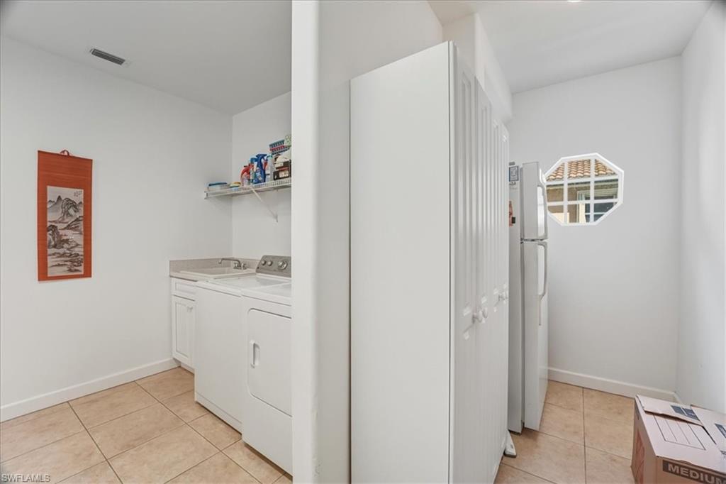 Washroom with light tile patterned floors and cabinet space
