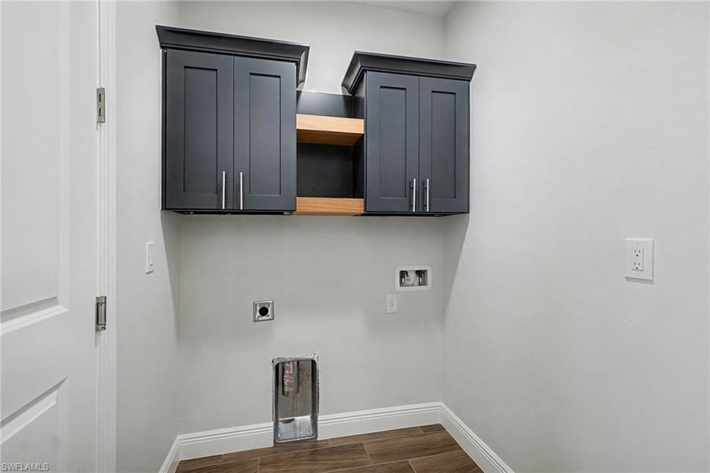 Washroom with cabinet space, hookup for an electric dryer, wood tiled floors, and hookup for a washing machine