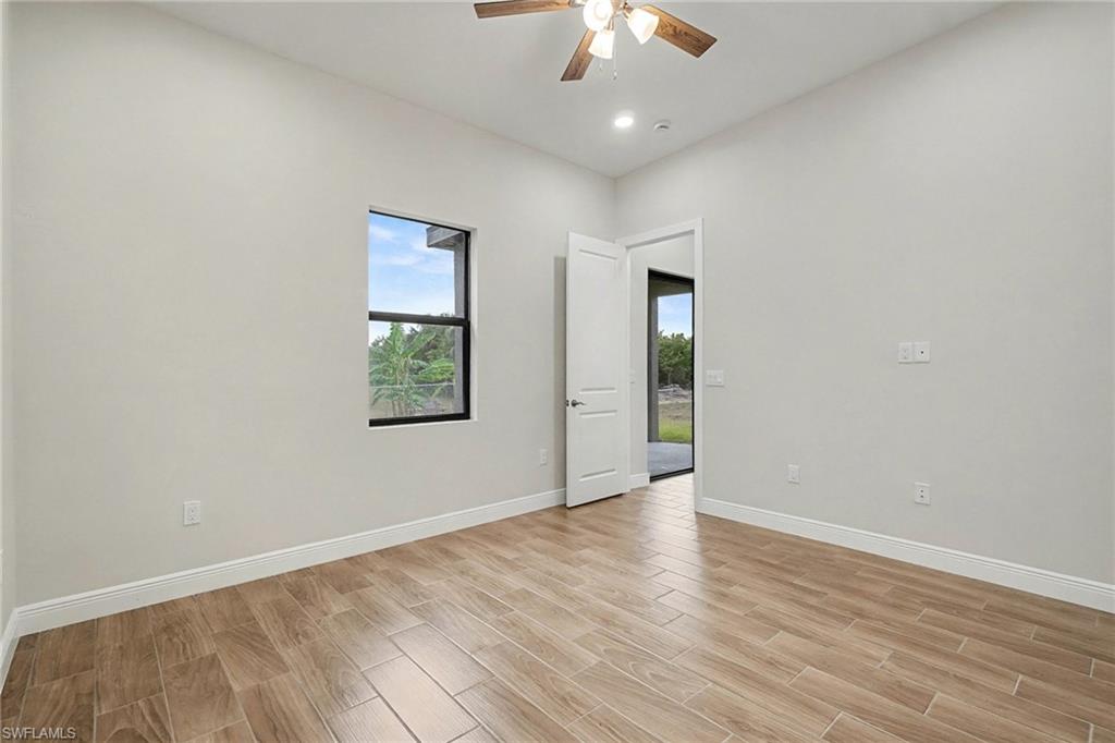 Empty room with wood finish floors and a ceiling fan