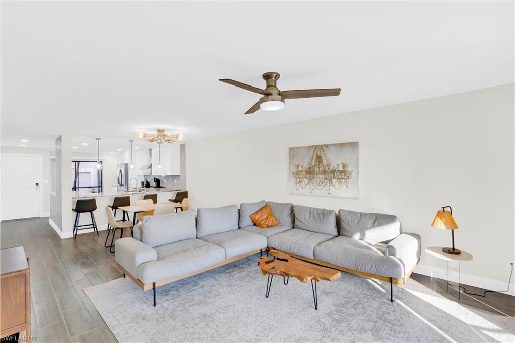 Living room with a chandelier, wood tiled floors, and a ceiling fan