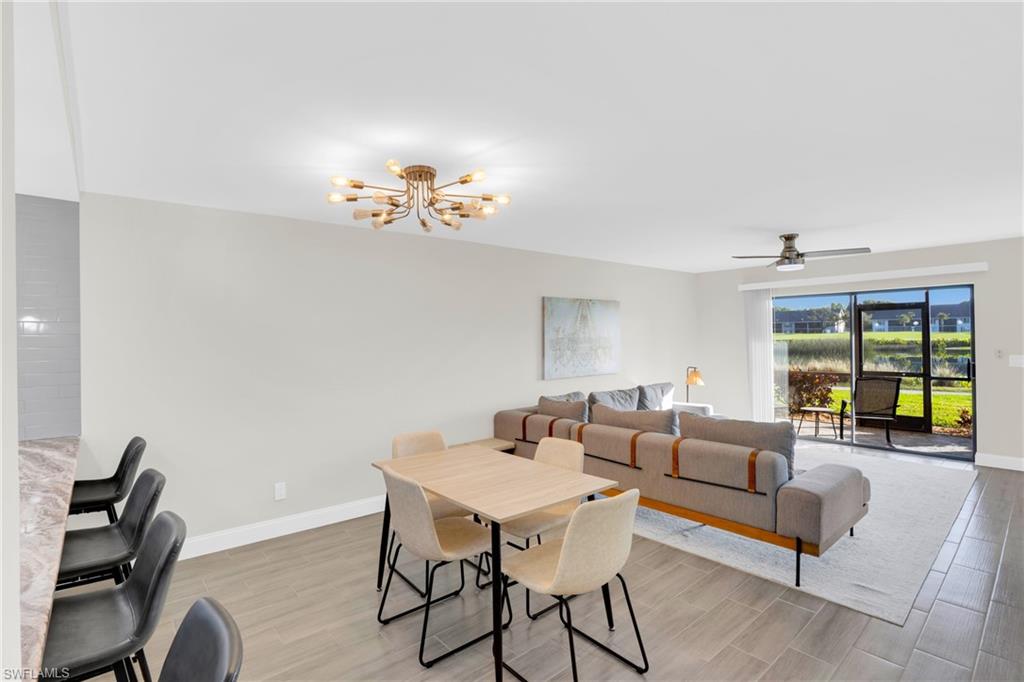Dining area with a chandelier, wood tiled floors, and a ceiling fan
