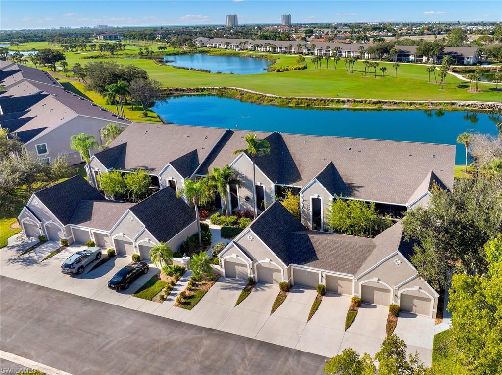 Aerial view of residential area featuring a nearby body of water and a local golf course