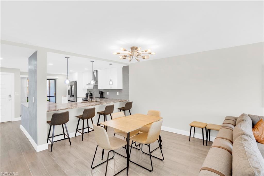 Dining space with wood tiled floors, a chandelier, and recessed lighting