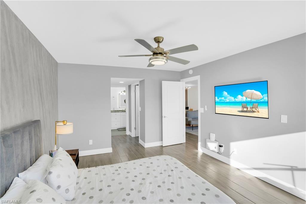 Bedroom featuring wood finish floors, ceiling fan, and ensuite bathroom