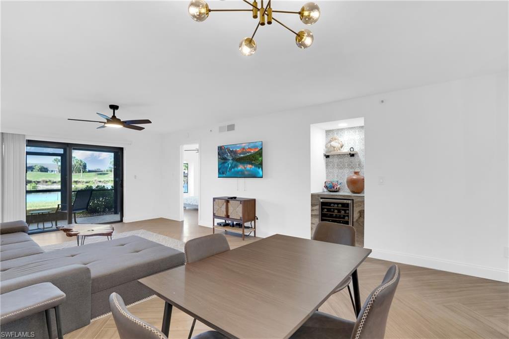 Living area with a chandelier, ceiling fan, and a water view