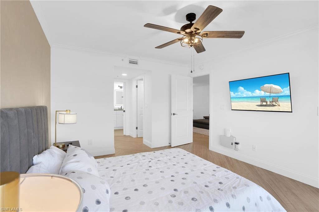 Bedroom with ornamental molding, light wood-style floors, and a ceiling fan