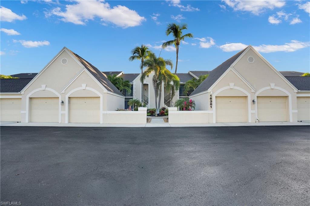 View of front of home featuring stucco siding and community garages