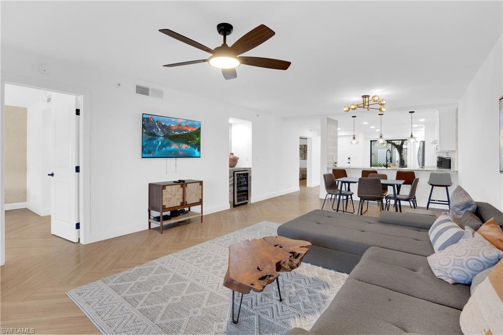 Living room with a ceiling fan, wine cooler, and a chandelier