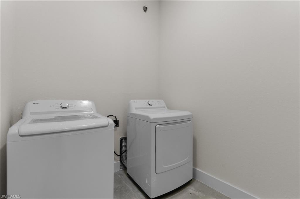 Washroom with baseboards and separate washer and dryer