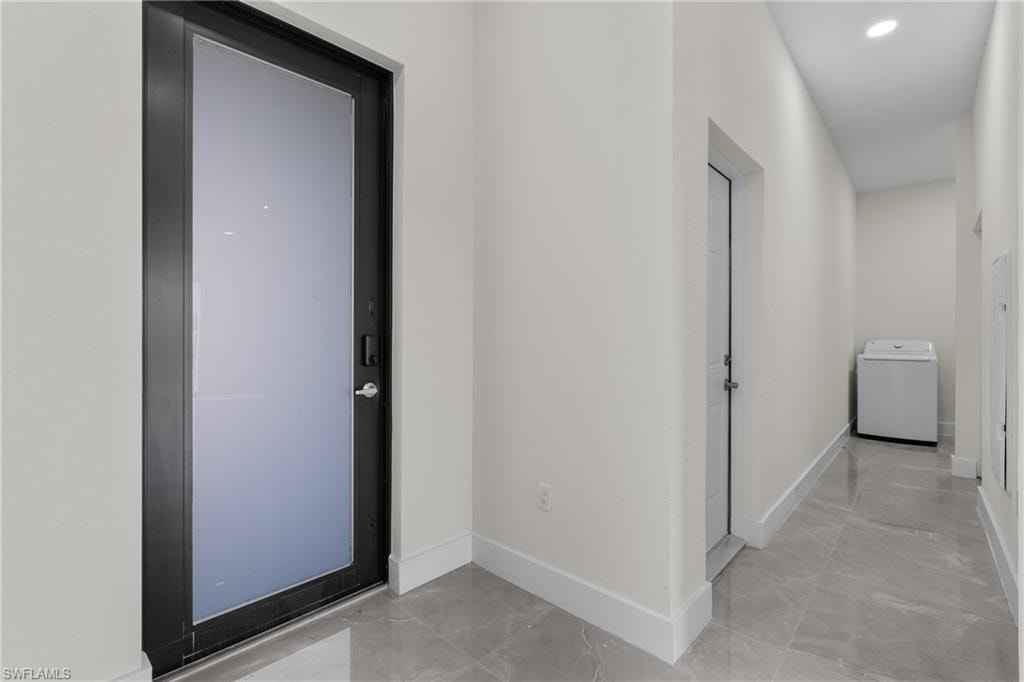 Hall featuring washer / dryer and recessed lighting
