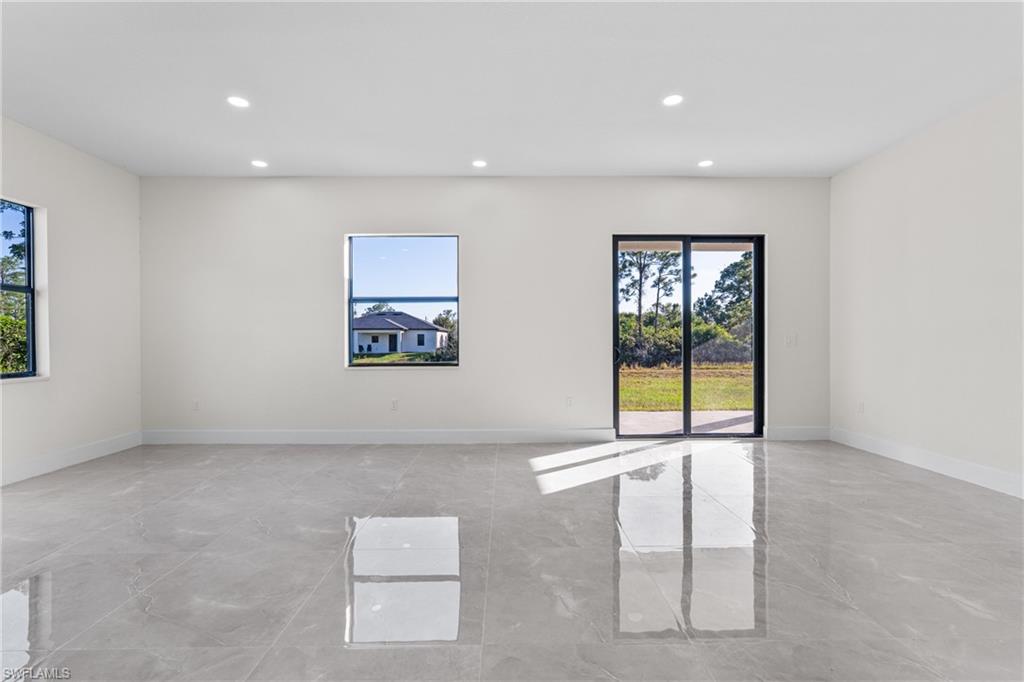 Spare room with recessed lighting, healthy amount of natural light, and light marble finish floors