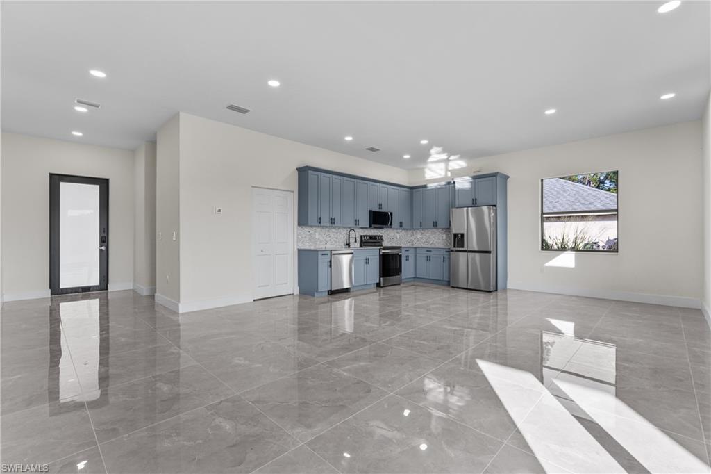 Unfurnished living room with recessed lighting and light marble finish flooring