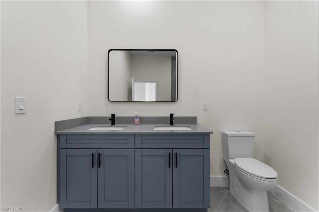 Bathroom with double vanity and baseboards