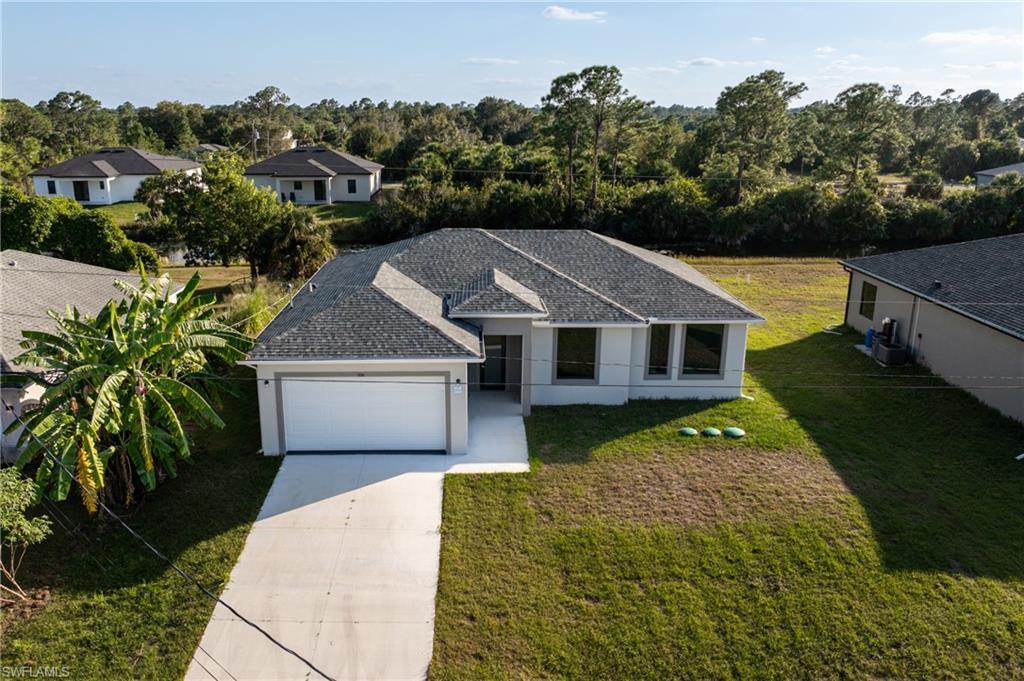 Single story home with driveway, a front lawn, stucco siding, a garage, and a shingled roof