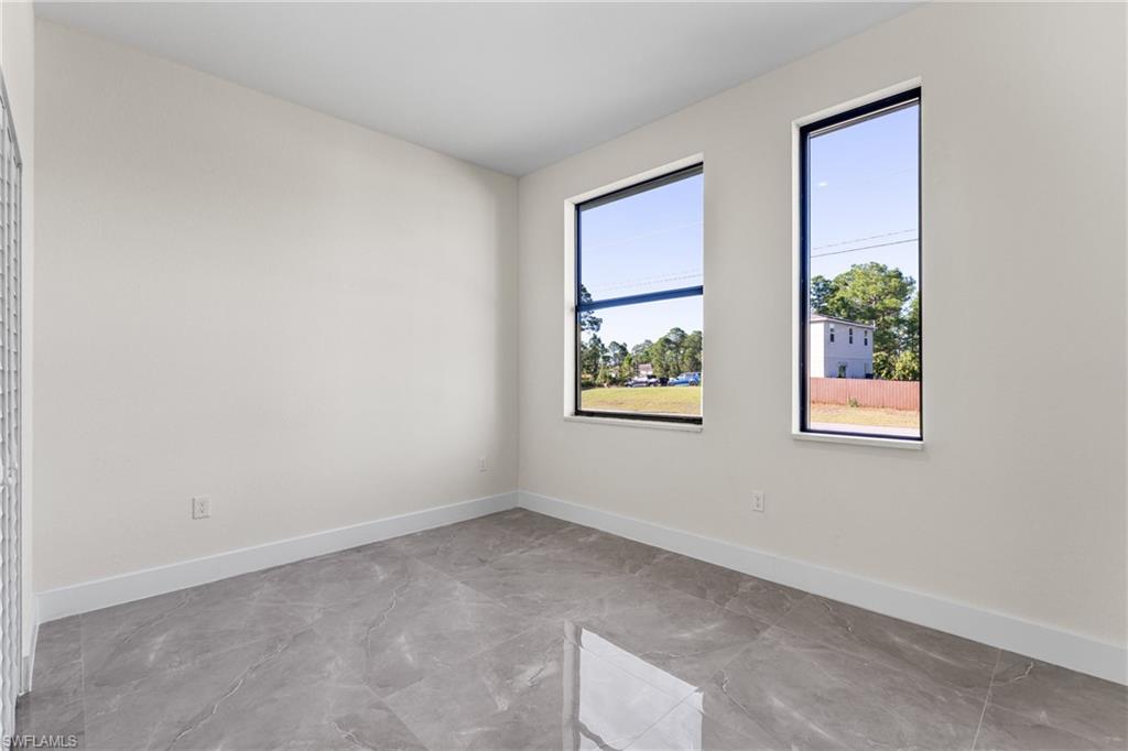 Unfurnished room with baseboards and light marble finish flooring
