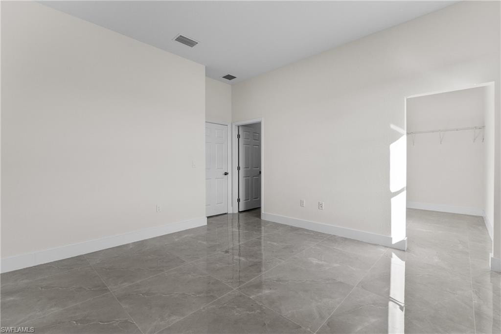 Unfurnished room with light marble finish floors