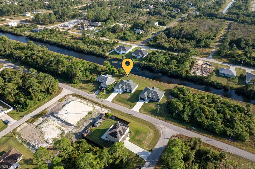 Aerial view of property and surrounding area with a nearby body of water and nearby suburban area