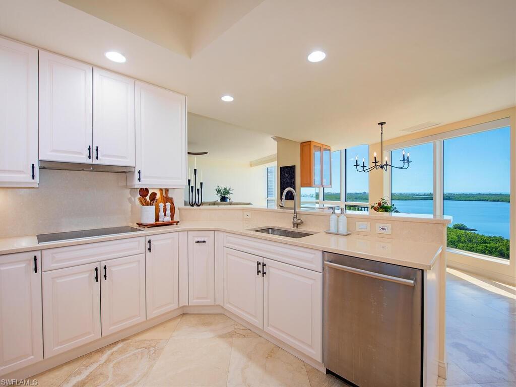 Kitchen with dishwasher, white cabinetry, a chandelier, hanging light fixtures, and recessed lighting