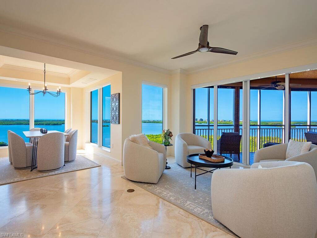 Living area featuring a water view, ornamental molding, a chandelier, and plenty of natural light