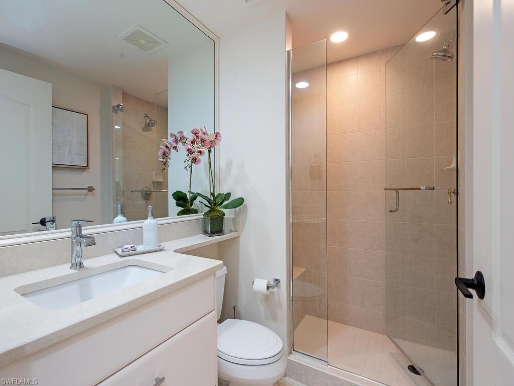 Full bathroom with vanity, a stall shower, and recessed lighting