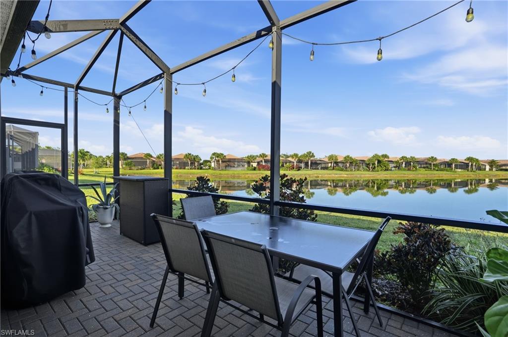 Sunroom with a water view, brick patterned floors, and a residential view