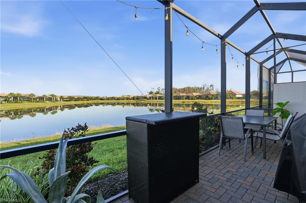 Sunroom with a water view, a residential view, and a patio area