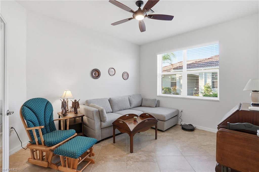 Living area with light tile patterned floors and ceiling fan