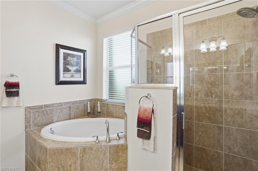 Full bathroom with a bath, a stall shower, and ornamental molding