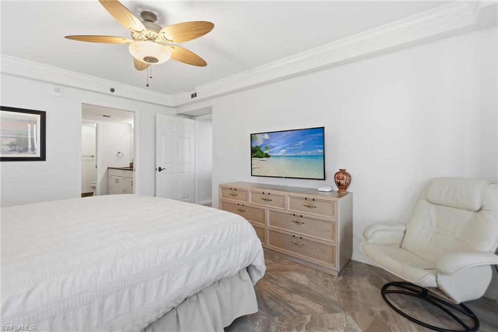 Bedroom featuring ornamental molding, ceiling fan, and ensuite bath