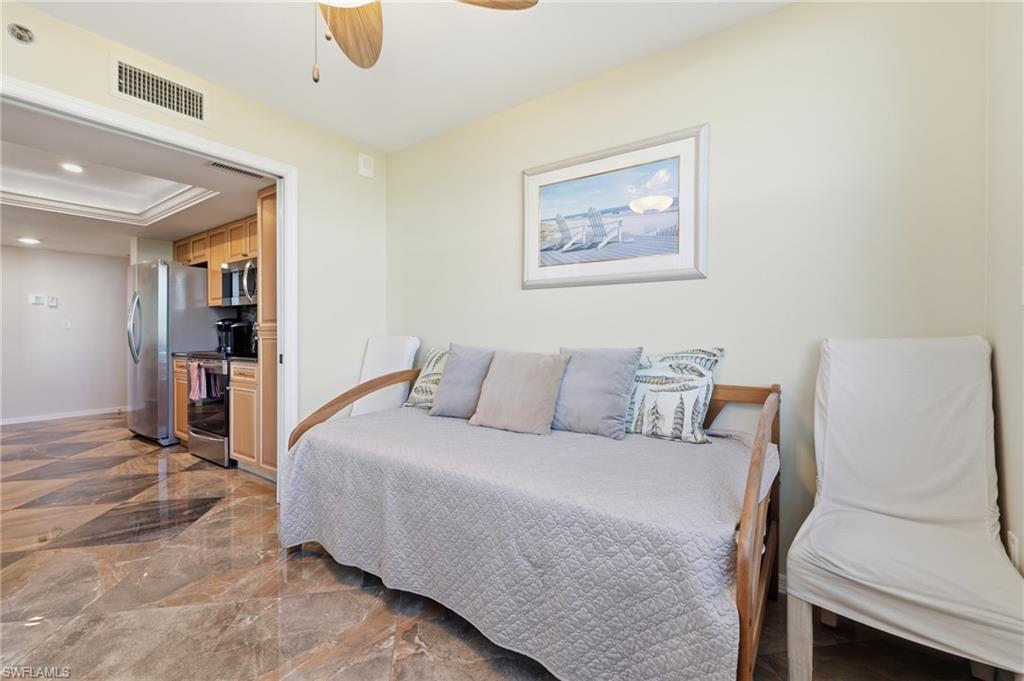 Bedroom featuring recessed lighting, ceiling fan, dark marble finish flooring, a raised ceiling, and freestanding refrigerator