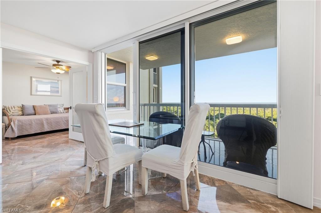 Dining room featuring expansive windows, a ceiling fan, and light marble finish flooring