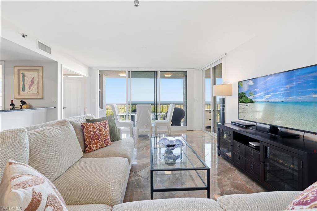 Living area featuring a wall of windows and marble tiled flooring