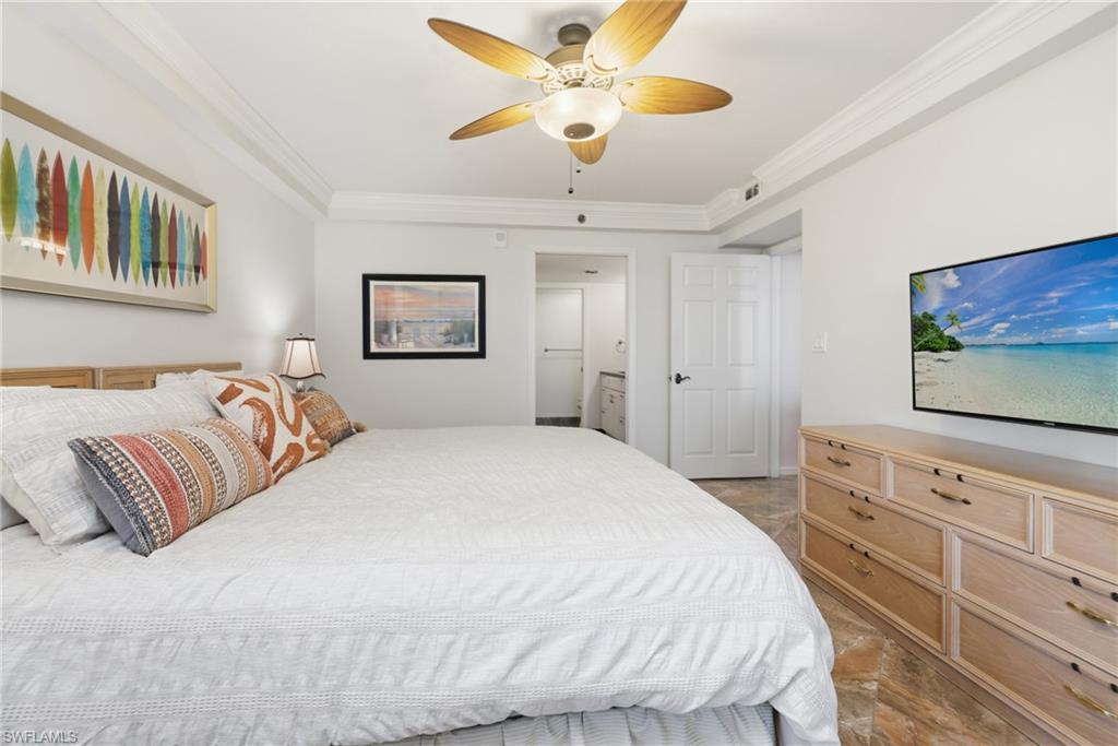 Bedroom featuring ornamental molding, ceiling fan, and ensuite bath