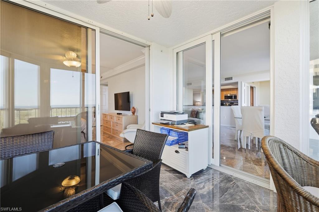 Dining room with ceiling fan, a desk, and dark marble finish flooring