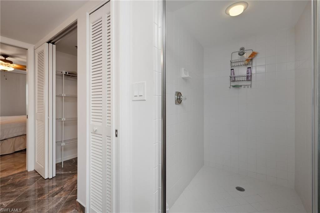 Ensuite bathroom featuring a stall shower and ceiling fan