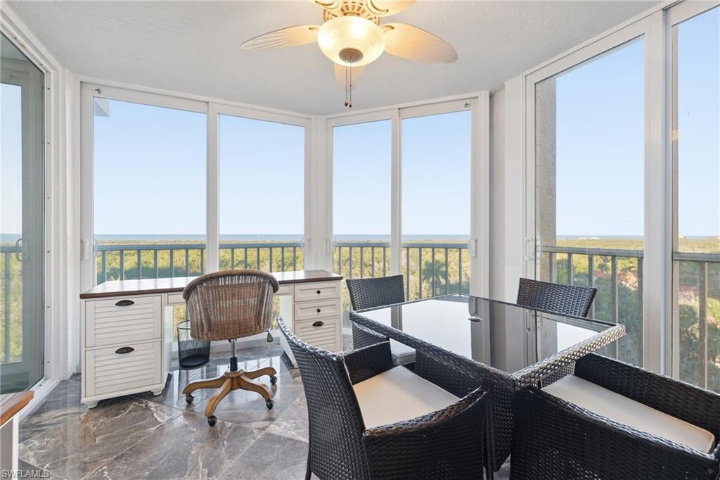 Sunroom featuring healthy amount of natural light, marble tiled floors, and a wall of windows