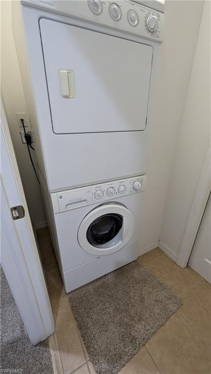 Laundry area with estacked washer and dryer and light tile patterned floors