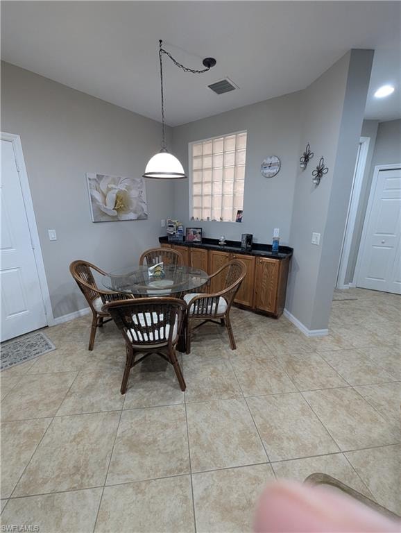 Dining area featuring light tile patterned floors and baseboards