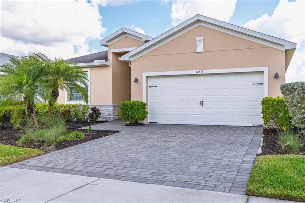 Ranch-style home with stucco siding, decorative driveway, and a garage