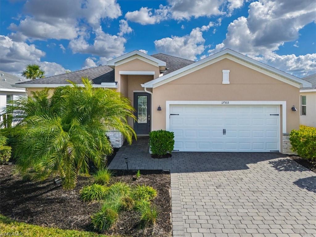 Ranch-style home featuring stucco siding, decorative driveway, and a garage