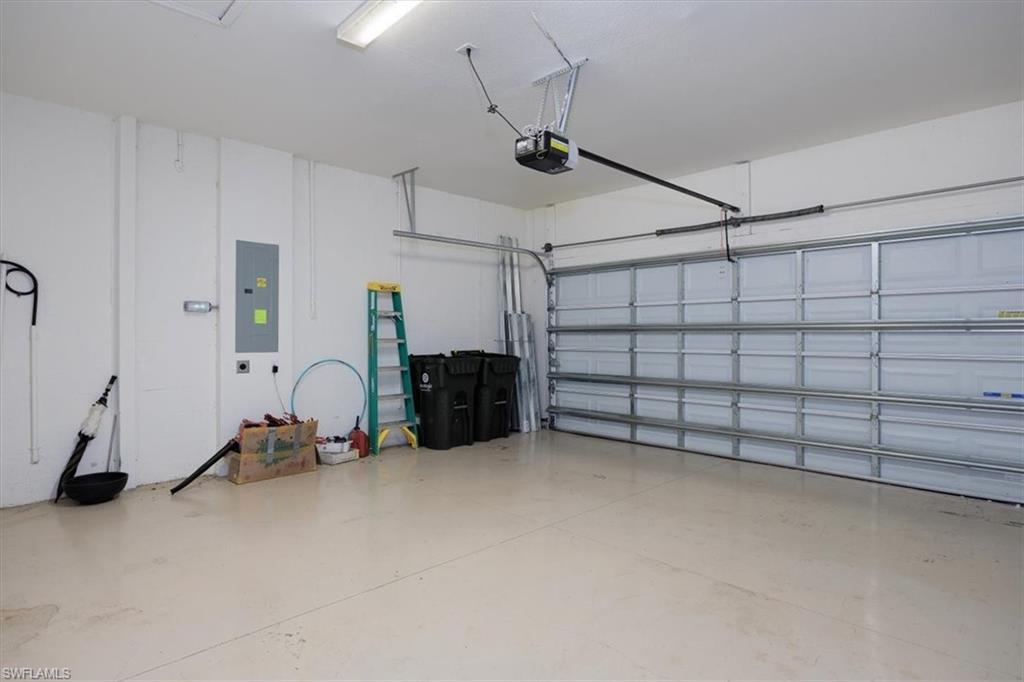 Garage featuring electric panel and an on demand Hot water hearter, electric car charging station and storm rated & reinforced garage door system.