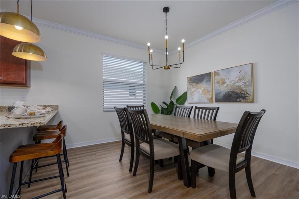 Dining room featuring ornamental molding, easy care flooring and a chandelier