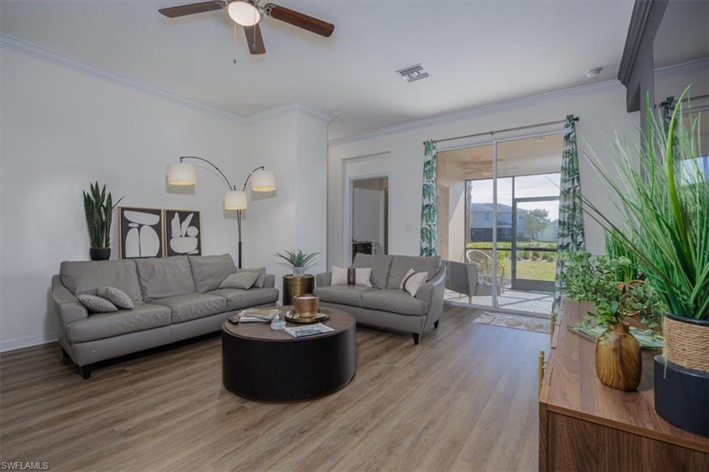 Living area with easy care flooring, crown molding, and ceiling fan featuring light