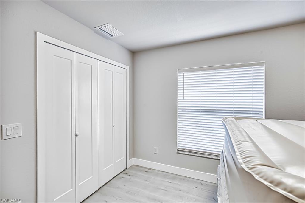 Bedroom with light wood-style flooring and a closet