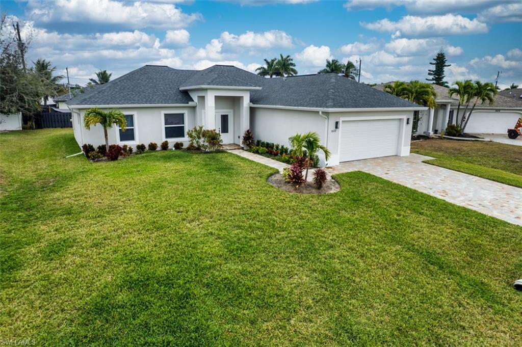 Ranch-style home with stucco siding, decorative driveway, an attached garage, and roof with shingles