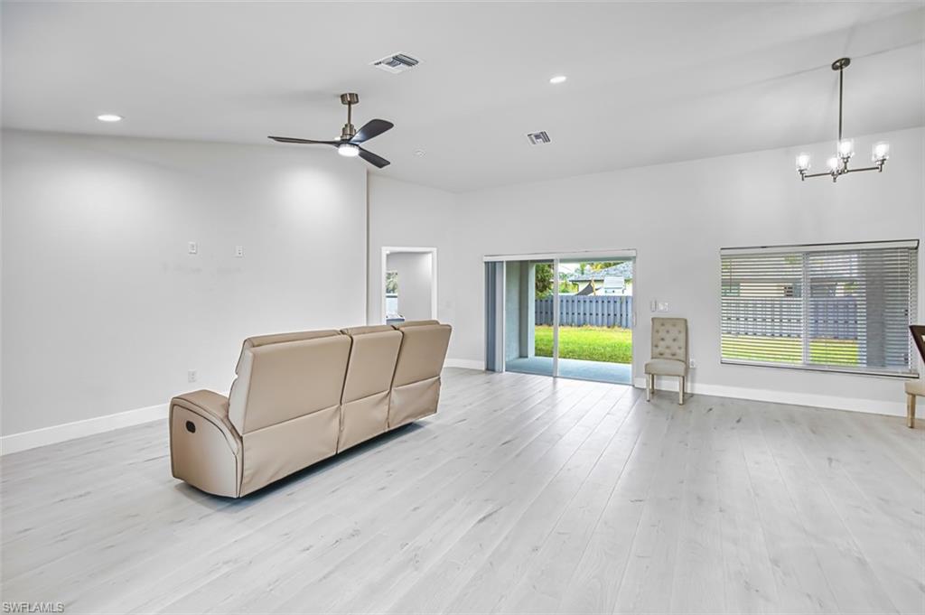 Unfurnished living room with recessed lighting, light wood-style flooring, a chandelier, and ceiling fan