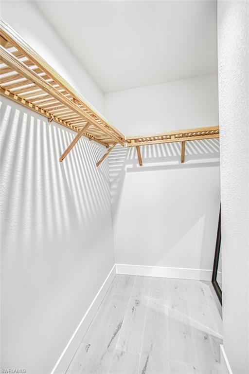 Spacious closet with light wood finished floors