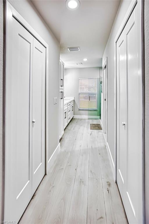 Hallway with recessed lighting and light wood-style flooring
