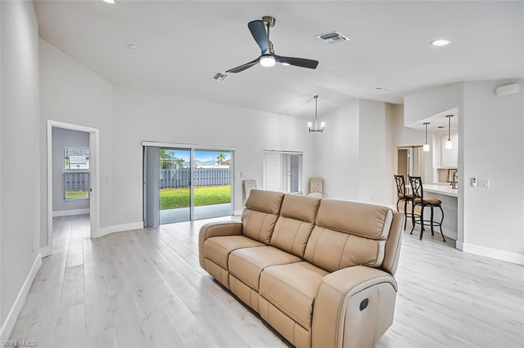 Living room featuring a ceiling fan, recessed lighting, light wood finished floors, and a chandelier
